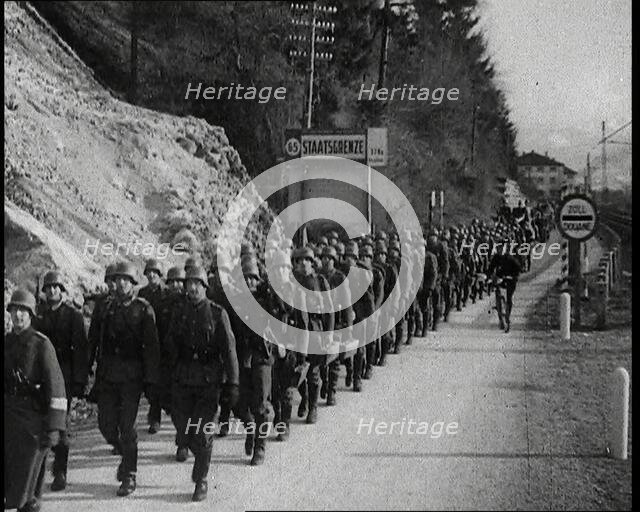 A Line of Male German Soldiers Marching Through a Customs Point Alongside a High Bank..., 1938. Creator: British Pathe Ltd.