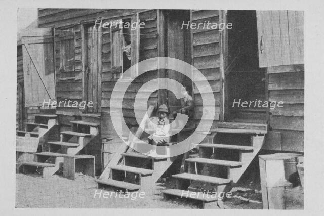 African American children sitting on the stairs in front of their house, 1922. Creator: Unknown.