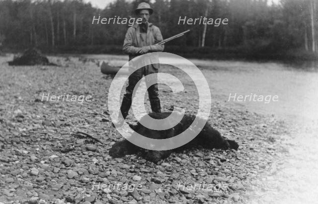 Hunter with bear which he killed, between c1900 and 1927. Creator: Unknown.
