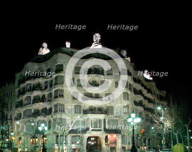 Façade of the Mila House or Pedrera lit at night, by Antoni Gaudí i Cornet (1852 - 1926).