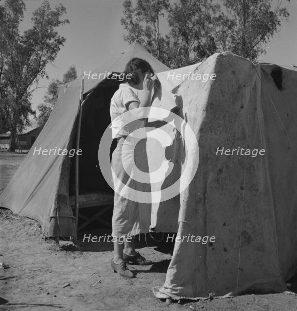 Woman in a California pea pickers' camp, mending the tent, 1937. Creator: Dorothea Lange.