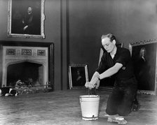 Edward, Lord Montagu of Beaulieu scrubbing floors in Palace House 1952. Creator: Unknown.