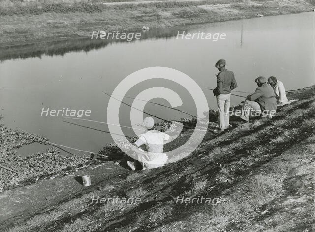 African American migrant laborers fishing in Belle Glade, Florida, January 1939. Creators: Farm Security Administration, Marion Post Wolcott.