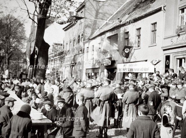 The poor enjoying a one-dish meal to the strains of music, Germany, 1936. Artist: Unknown