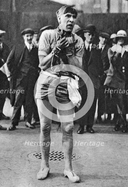Escapologist entertaining theatre-goers in the 'pit' queue, London, 1926-1927. Artist: Unknown
