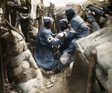 'First aid to a wounded man in one of the French trenches', 1915. Artist: Unknown.