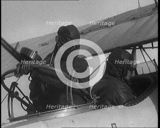 Male British Pilots On Board a Plane And Mounting a Machine Gun, 1920s. Creator: British Pathe Ltd.