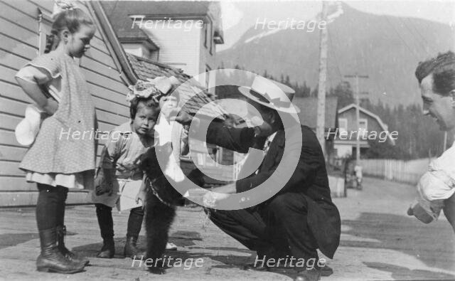 White people with bear cub, between c1900 and c1930. Creator: Unknown.