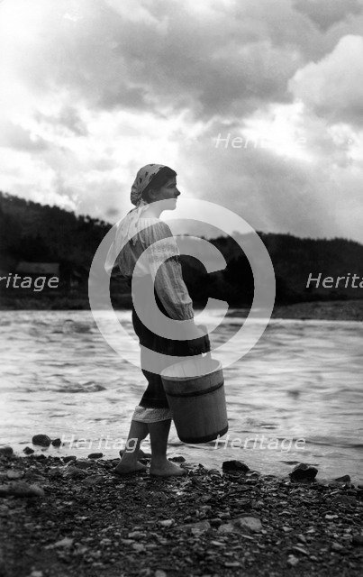 Young woman with a bucket, Bistrita Valley, Moldavia, north-east Romania, c1920-c1945. Artist: Adolph Chevalier