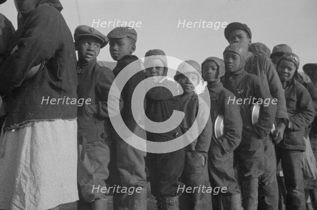 Possibly: Negroes in the lineup for food at the flood refugee camp, Forrest City, Arkansas, 1937. Creator: Walker Evans.