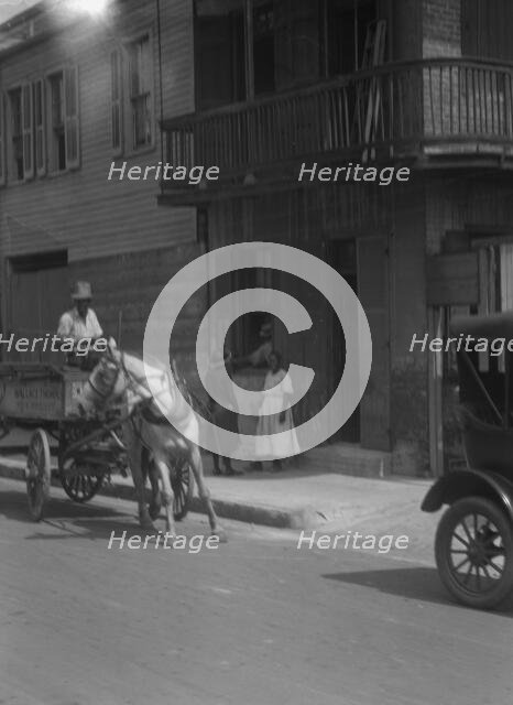 Street scene, including horse- or mule-drawn wagon, New Orleans, between 1920 and 1926. Creator: Arnold Genthe.