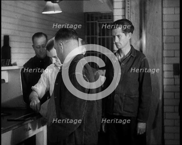 A group of Male Americans Civilians Wearing Prisoners Outfits Having Their Finger Prints..., 1930. Creator: British Pathe Ltd.