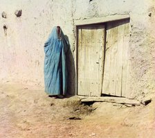 Woman in purdah, standing near wooden door, between 1905 and 1915. Creator: Sergey Mikhaylovich Prokudin-Gorsky.
