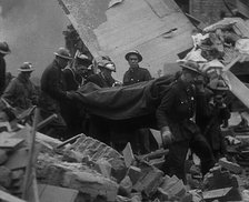 Firefighters Carrying Out a Corpse from a Bombed Out Building, 1940. Creator: British Pathe Ltd.