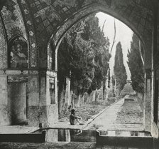 Reproduction of print showing Garden at Fin-Nahe¯, Kashan, Iran. Man seated under arch , c1920. Creator: Frances Benjamin Johnston.