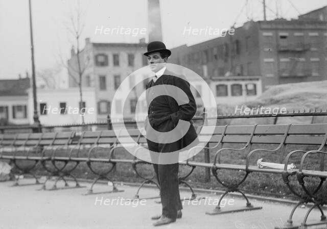 Umberto Blaisie standing in front of park benches, 1910. Creator: Bain News Service.