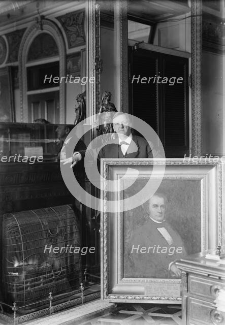 Daniels, Josephus, Secretary of The Navy, 1913-1921 with Painting of Secretary of The Navy..., 1913. Creator: Harris & Ewing.