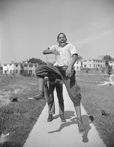 Boys playing leap frog near the project, Frederick Douglass housing project, Anacostia, D.C., 1942. Creator: Gordon Parks.