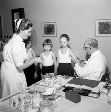 A doctor and his nurse vaccinate schoolgirls againgst polio, Landskrona, Sweden, 1957. Artist: Unknown