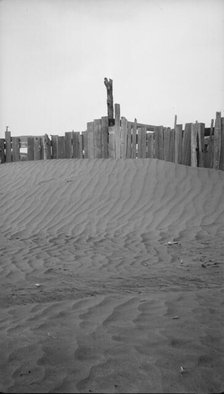 A corral practically buried by drifted dust, Mills, New Mexico., 1935. Creator: Dorothea Lange.