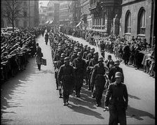 Crowd Watching German Soldiers Marching Down a Street Towards the Camera, 1930s. Creator: British Pathe Ltd.