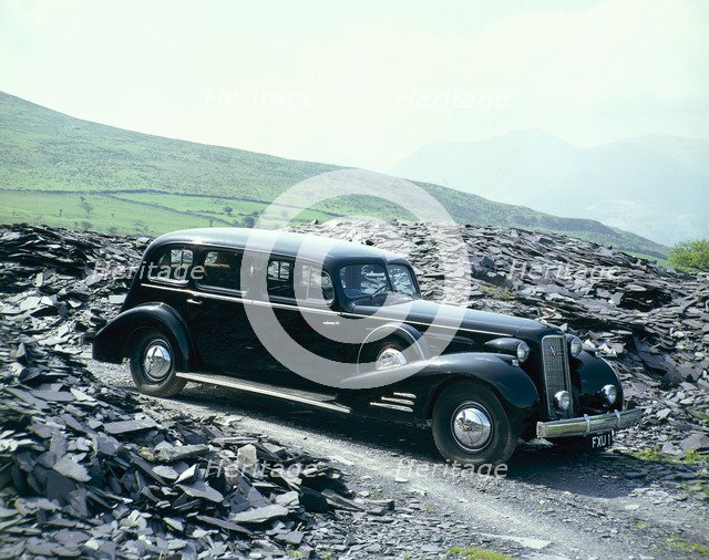 A 1937 Cadillac V16 sedan, photographed among piles of slate. Artist: Unknown