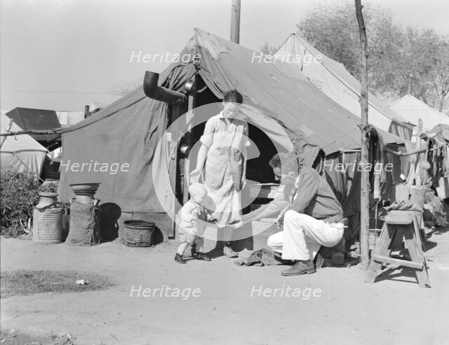 Tom Collins, manager of Kern migrant camp, with drought refugee family, California, 1936. Creator: Dorothea Lange.