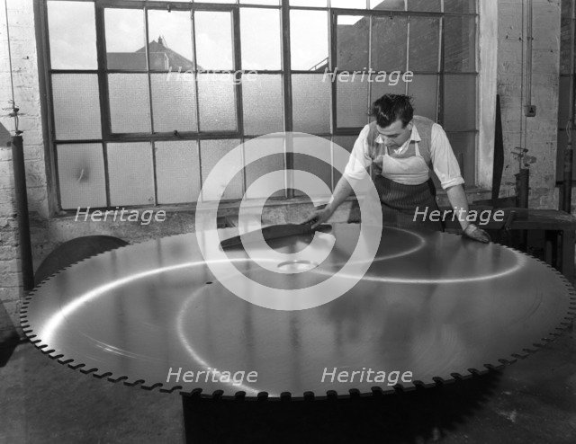 Quality checking a giant saw blade, Edgar Allen's steel foundry, Sheffield, South Yorkshire, 1963.  Artist: Michael Walters