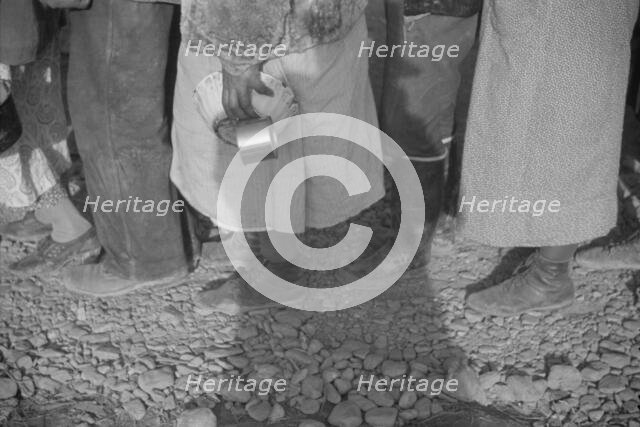 Possibly: Negroes at mealtime in the flood refugee camp, Forrest City, Arkansas, 1937. Creator: Walker Evans.