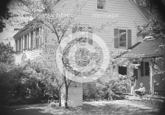 DeLamar, Alice, Miss, and unidentified woman by house, between 1927 and 1942. Creator: Arnold Genthe.