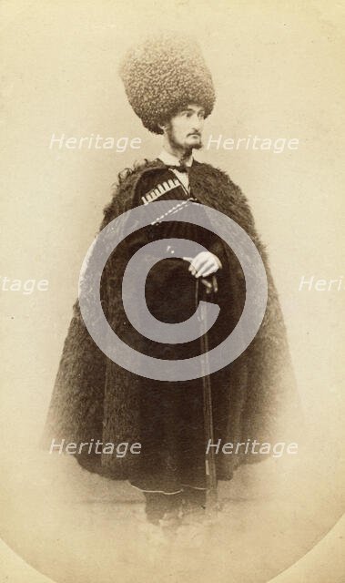 Full-length portrait of a man in cape and sheep skin hat, holding a rifle..., between 1870 and 86. Creator: Unknown.