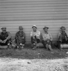 Possibly: Idle men seated in shade on the other side..., Tulelake, Siskiyou County, California, 1939 Creator: Dorothea Lange.