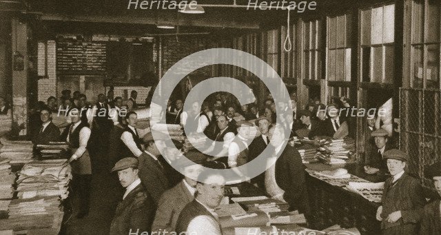 Newsvendors gather to pick up the next day's newspapers to sell, Carmelite House, 20th century. Artist: Unknown