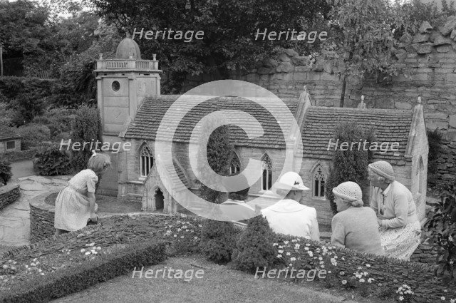 A group of women and a child admire the church in the model village at Corfe Castle, c1945-c1965. Artist: SW Rawlings