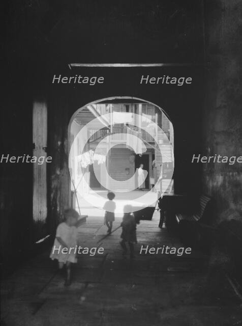 Children playing in an arched passageway, New Orleans, between 1920 and 1926. Creator: Arnold Genthe.