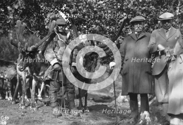 Tourists posing alongside a man with reindeer, Lyngen, Norway, 1929. Artist: Unknown