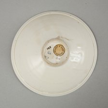 A shallow cream glazed bowl with rolled rim andraised footrim, Tang dynasty, c.800-900. Artist: Unknown.