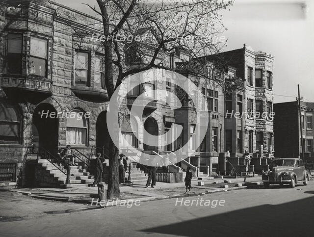 Old brown stonehouses now occupied by Negroes in Chicago, Illinois, April 1941. Creators: Farm Security Administration, Russell Lee.