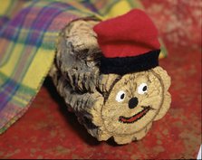 Tió de Nadal' (Christmas log) with barretina (typical Catalan hat) and half covered with a blanket.
