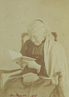 Elderly woman seated and reading a book with knitting in her lap, 1895. Creator: Horace L Bundy.