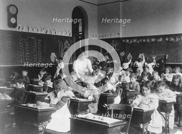 Children modeling clay at desks and drawing on blackboard in Washington, D.C. classroom, (1899?). Creator: Frances Benjamin Johnston.