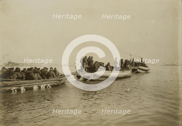Steam launch carrying six over-crowded boat loads soldiers to landing, Chemulpo, c1904. Creator: Robert Lee Dunn.