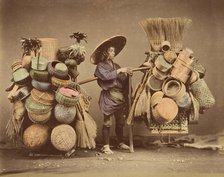 [Japanese Man Posing with Baskets, Brooms and Feather Dusters], 1870s. Creator: Unknown.