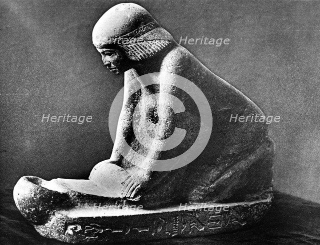 Egyptian tomb figure of a woman grinding corn using a saddle quern, c2500 BC. Artist: Unknown