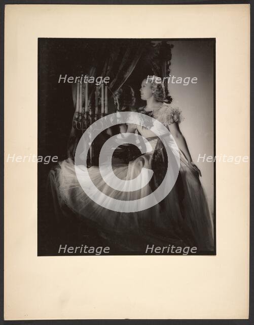 Woman lighting candelabra, 1930s. Creator: Gunther Krampf.