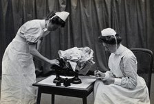 General Lying In Hospital, York Road, Lambeth: nurses weighing a baby, 1906 Creator: Unknown.