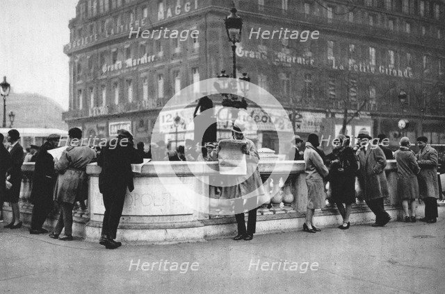 Meeting place at the entrance to a Metro station, Paris, 1931. Artist: Ernest Flammarion